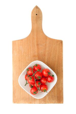 Fresh tomatoes on a wooden kitchen plateの写真素材