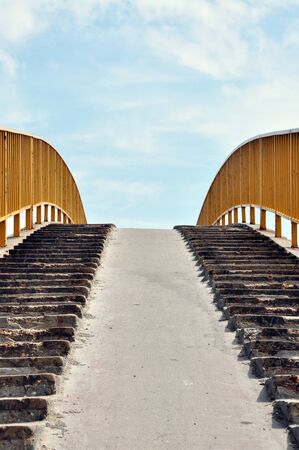 Detail of a concrete bridge against the blue cloudy sky.