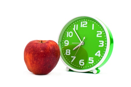 Alarm clock on the white and an apple の写真素材