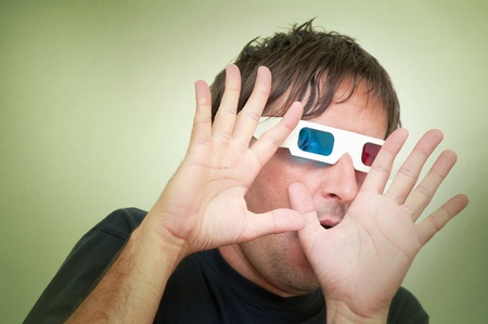 Man with anaglyph 3D glasses making funny face with his hands up.の写真素材