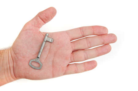 Male hand holding a key to the house, image is taken over a white background.の写真素材