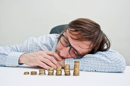 Businessman siting at the table and thinking about possible dollar invesments.の写真素材