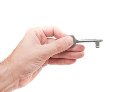 Male hand holding a key to the house, image is taken over a white background.の写真素材