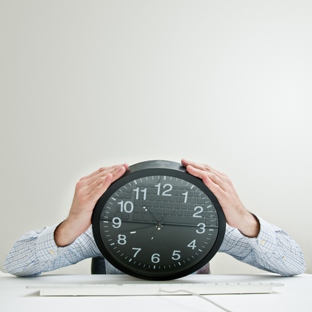 Desperate businessman with a clock instead of his head, looking desperately down as the time passes...