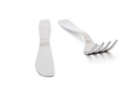 Kitchen knife and a fork, beautiful silverware on a white background. Image is taken with selective focus and very shallow depth of field.の写真素材