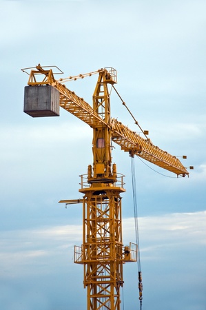 Yellow construction crane on a cold, cloudy day.の写真素材