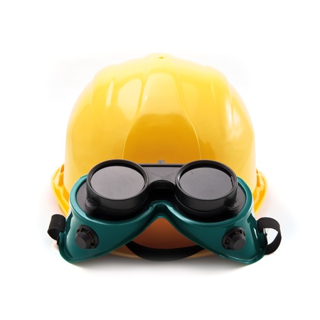 Yellow hard hat and protective plastic goggles, protective equipment in construction industry.の写真素材