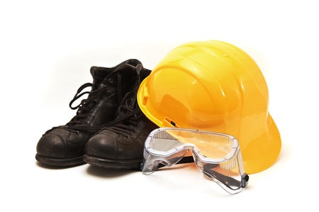 Yellow hard hat, old leather boots and protective goggles, protective equipment in construction industry.の写真素材