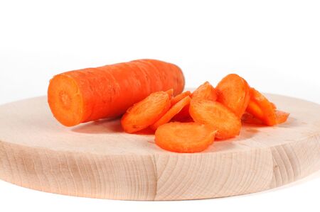 Carrot slices on a wooden plate over a white backgroundの写真素材