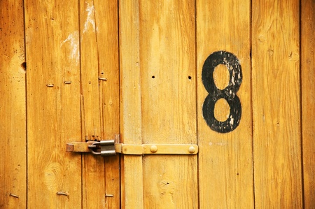 Old wooden garage door with number eight written on it 