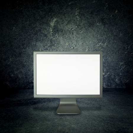Computer monitor in a grunge concrete roomの写真素材