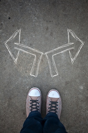 Male sneakers on the asphalt road with drawn direction arrowの写真素材