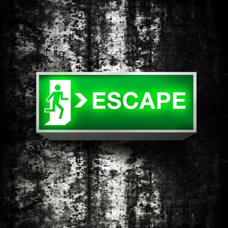 Fire emergency exit sign on a grunge obsolete wallの写真素材