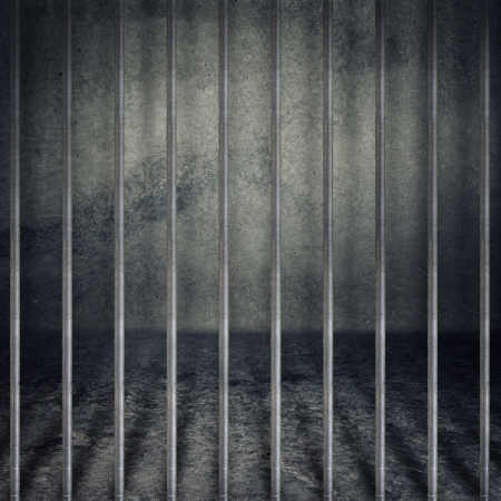 Obsolete gray grunge concrete room, prison cell with metal bars.の写真素材