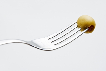 Paprika stuffed olive speared on a silver forkの写真素材