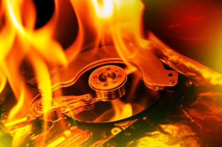 Close up image of computer hard disk on fire, burning in flasmes.の写真素材