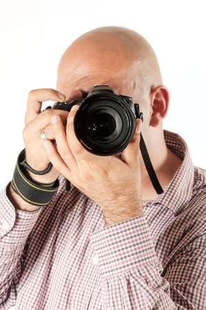 Bold male photographer taking a picture with a dslr cameraの写真素材