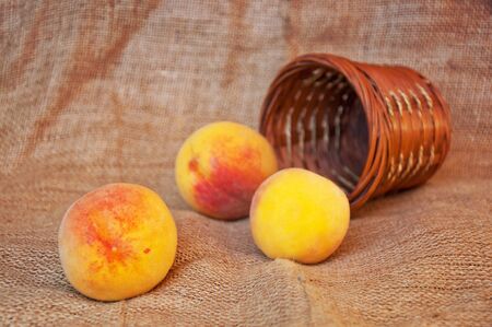 Tasty fresh ripe peaches and a punnet on a table.の写真素材