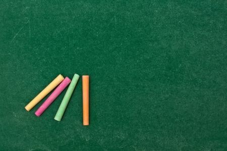 Colorful chalks on grungy green chalkboard textureの写真素材
