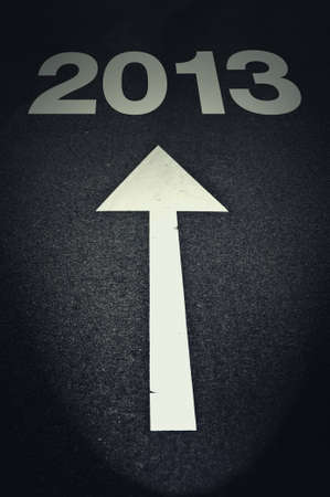 Towards new year of 2013, arrow sign on the road lit by the car light 