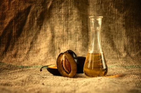 Plum brandy or schnapps with fresh and tasty plum fruit on a table clothの写真素材