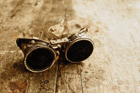 Vintage welder protective mask on a wooden tableの写真素材