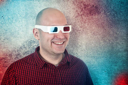 Portrait of a smiling man with anaglyph glasses enjoying a 3d movie.
