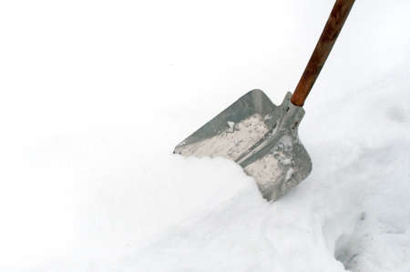 Snow shovel in a deep snow, winter is hereの写真素材