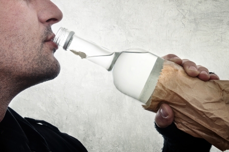 Man is drinking vodka from the bottle, alcoholism concept.の写真素材