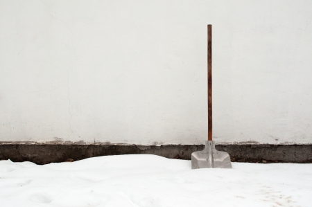 Snow shovel in a deep snow, winter is hereの写真素材