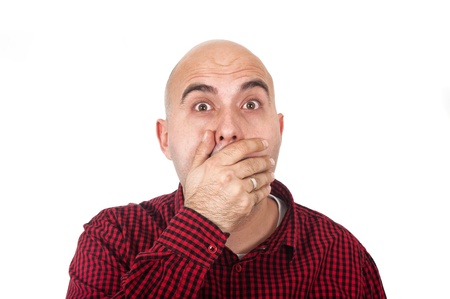 Young adult bald man with hand on mouthの写真素材