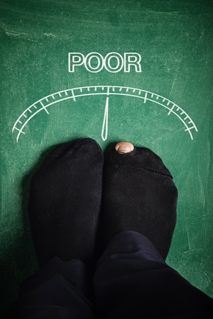 Poor man standing at poverty meter, conceptual image の写真素材