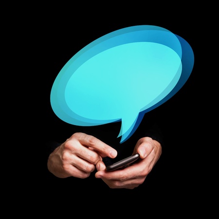 Man typing text message on his smartphone with speech balloon over itの写真素材