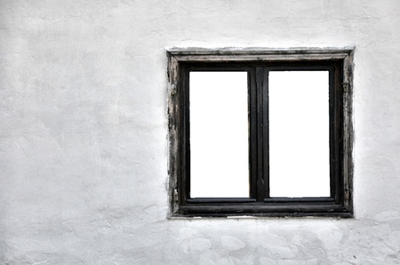 Old wooden window with cutout panes on a grungy white wall の写真素材