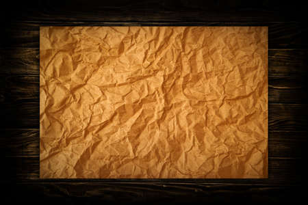 Crumpled paper on wood texture, background for your design.の写真素材