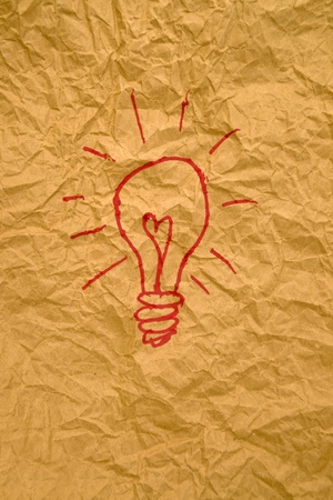 Idea light bulb drawing on crumpled yellow paper texture.の写真素材