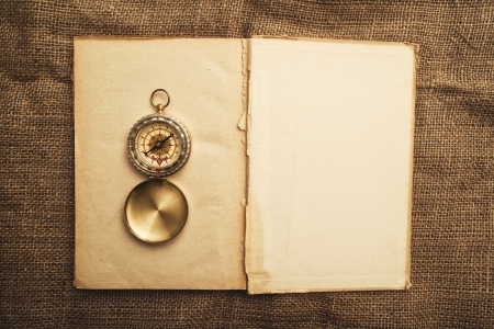 Vintage open book with old navigation compass.の写真素材