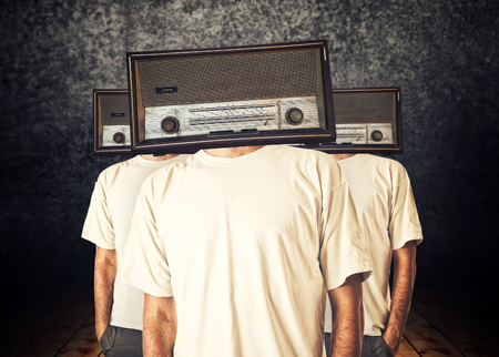 People with radio heads in dark vintage roomの写真素材