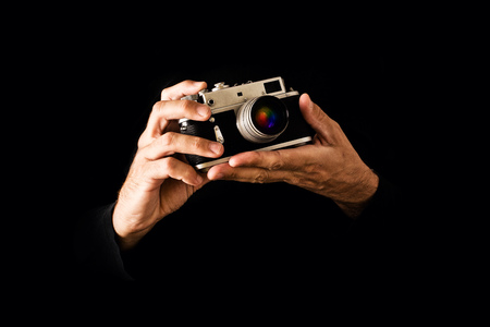 Man Holding Vintage Photography Camera on black background の写真素材