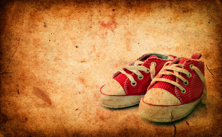 Baby sneakers on grunge old paperの写真素材