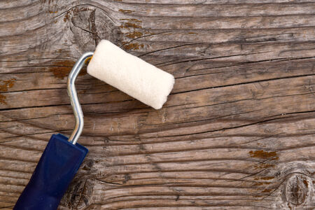 Small paint roller on old wood background  Redecoration and renovation concept の写真素材