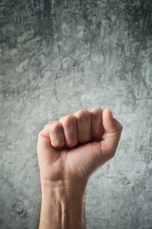 Raised fist for protest. Clutching the hand of man.の写真素材