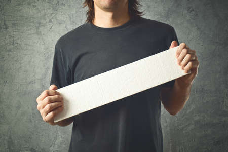 Man holding blank white banner with copy space for your text 