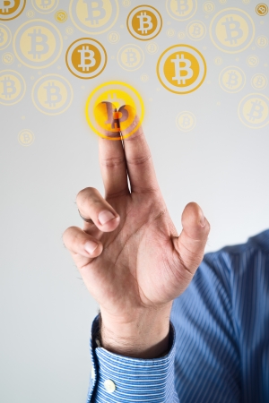Collecting bitcoins, businessman pressing bitcoin icon  Conceptual image の写真素材