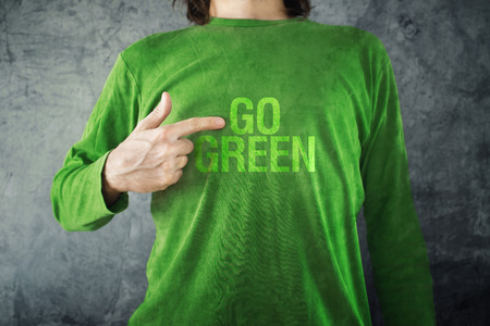 Man pointing to GO GREEN title printed on his shirt, healthy lifestyle concept.の写真素材