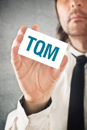 Total Quality Management consultant. Businessman holding TQM card. Selective focus.の写真素材