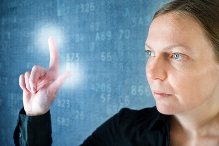 Attractive businesswoman pressing touch screen button, modern technolgy concept.の写真素材