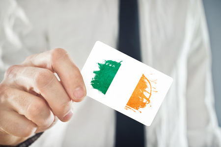 Irish Businessman holding business card with Ireland Flag. International cooperation, investments, business opportunities concept.の写真素材