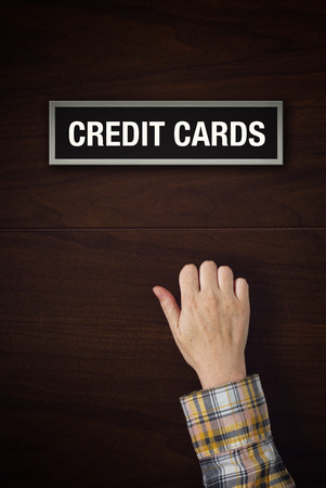 Female hand is knocking on Credit Cards  bank department door looking for a serviceの写真素材