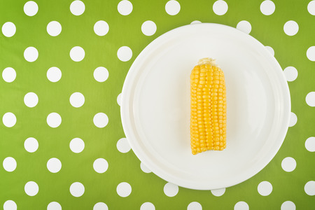 Cooked Corn maize cob half on a flat plate served as a dieting dinner.の写真素材